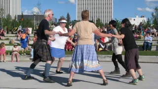 Dancers holding hands at Frame Lake Park 
