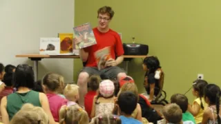 James reading to a handful of youth at the library 