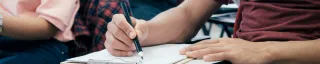 student writing on a paper