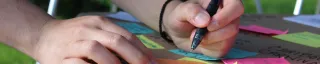 Person writing on sticky notes