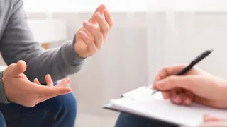 A man speaking expressively while being recorded by another person
