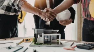 Three people shaking hands confirming a deal