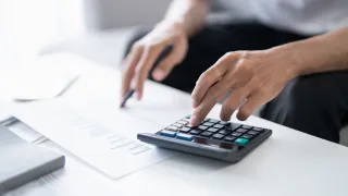 Man calculating taxes with his calculator