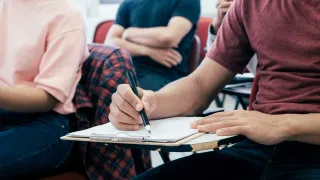 student writing on a paper