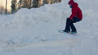 Snowboarder rides a rail at Bristol Pit