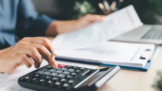 A man calculating tax with a calculator